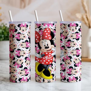 K&ouml;nnte beinhalten: Drei hohe, zylindrische Becher mit wei&szlig;en Strohhalmen. Zwei Becher zeigen ein sich wiederholendes Muster von Minnie Mouse-Gesichtern mit rosa Schleifen und Tupfen. Der mittlere Becher zeigt Minnie Mouse in einem roten Tupfenkleid und einer Schleife.