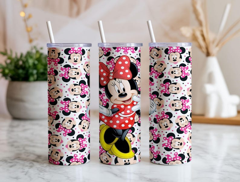 K&ouml;nnte beinhalten: Drei hohe, zylindrische Becher mit wei&szlig;en Strohhalmen. Zwei Becher zeigen ein sich wiederholendes Muster von Minnie Mouse-Gesichtern mit rosa Schleifen und Tupfen. Der mittlere Becher zeigt Minnie Mouse in einem roten Tupfenkleid und einer Schleife.