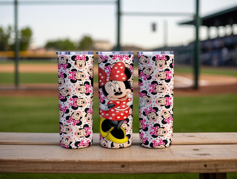 K&ouml;nnte beinhalten: Drei Edelstahlbecher mit Deckel. Ein Becher zeigt Minnie Mouse in einem roten gepunkteten Kleid und einer Schleife. Die anderen beiden Becher haben ein Muster aus Minnie Mouse-Gesichtern und rosa Punkten auf wei&szlig;em Hintergrund.