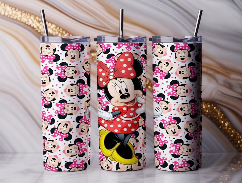 K&ouml;nnte beinhalten: Drei Edelstahlbecher mit Minnie-Maus-Motiv. Die Becher haben einen wei&szlig;en Hintergrund mit rosa Tupfen und Minnie-Maus-Gesichtern. Ein Becher hat ein vollst&auml;ndiges Minnie-Maus-Bild in einem roten Tupfenkleid. Jeder Becher hat einen silbernen Strohhalm.