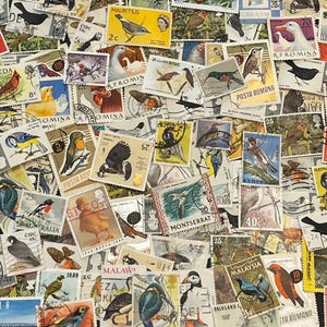 May include: A collection of vintage postage stamps featuring various colorful bird illustrations. The stamps are of different sizes and shapes, with text and numbers visible. The stamps are arranged in a scattered pattern.