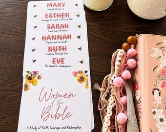 May include: A set of white cards titled Women of the Bible, featuring floral illustrations and bee motifs. The cards list names including Mary, Esther, Sarah, Hannah, Ruth, and Eve, each with a short phrase. A pink book with tassels and a candle are nearby.