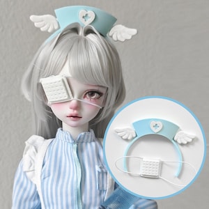 Könnte beinhalten: Eine Puppe mit hellblauer Krankenschwestermütze mit weißen Flügeln und einem herzförmigen Kreuz. Die Puppe hat eine weiße Augenklappe und trägt ein blau-weiß gestreiftes Hemd. Ein passendes Stirnband ist in einem Kreis abgebildet.