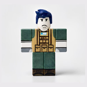 Puede incluir: Una figura en forma de bloque con peinado azul, cara blanca y un pequeño bigote. La figura lleva un chaleco color beige sobre un uniforme verde, con las letras "USH" visibles. La figura tiene brazos y piernas en forma de bloque y zapatos marrones.