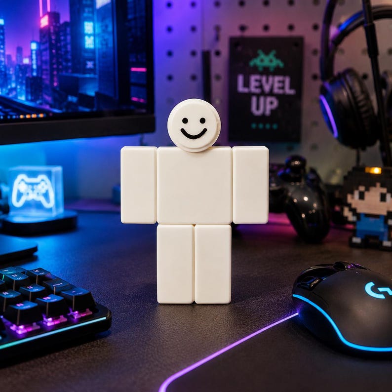 Puede incluir: Una figura blanca en forma de bloque con una cara sonriente, que se asemeja a un personaje de videojuego, est&aacute; sobre un escritorio. El fondo incluye un monitor de computadora, teclado, rat&oacute;n y un letrero que dice "LEVEL UP."