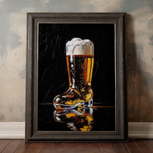 May include: Framed artwork depicting a beer boot glass filled with golden beer and a foamy head. The glass reflects on a glossy black surface. The artwork is in a dark wooden frame, set against a textured wall.