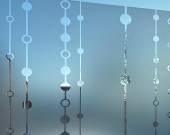 May include: A frosted glass window film featuring a repeating vertical pattern of thin lines interspersed with solid circles and open ring shapes. The translucent surface creates a semi-opaque effect, allowing light to pass through while obscuring views.