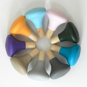 May include: A set of ten wooden knobs with different colored tops. The knobs are arranged in a circle, with the tops facing outwards. The colors of the knobs are light blue, pink, orange, purple, beige, gray, dark gray, teal, and dark green.