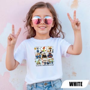 May include: White t-shirt featuring a colorful grid of Zootopia characters. The shirt has the text "IN ZOOTOPIA, ANYONE CAN BE ANYTHING" at the bottom. The model is wearing pink-tinted sunglasses and making a peace sign.