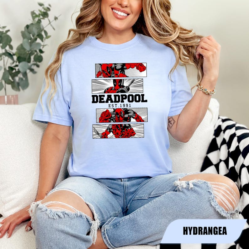 以下が含まれることがあります： デッドプールのグラフィックが特徴のライトブルーのTシャツ。デザインには、デッドプールのイラストが描かれた3つのパネルと、黒で「DEADPOOL EST. 1991」の文字が含まれています。このTシャツは、クルーネックで半袖です。