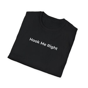 May include: Black t-shirt with the white text "Hook Me Right". The shirt is folded and displayed on a white background. The t-shirt is made of a soft material and has a crew neck.