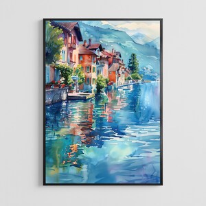 May include: A watercolour painting of a lakeside village with multi-coloured buildings in shades of orange, pink, and brown. The structures are situated along the water's edge, with reflections visible in the blue lake and mountains in the background.