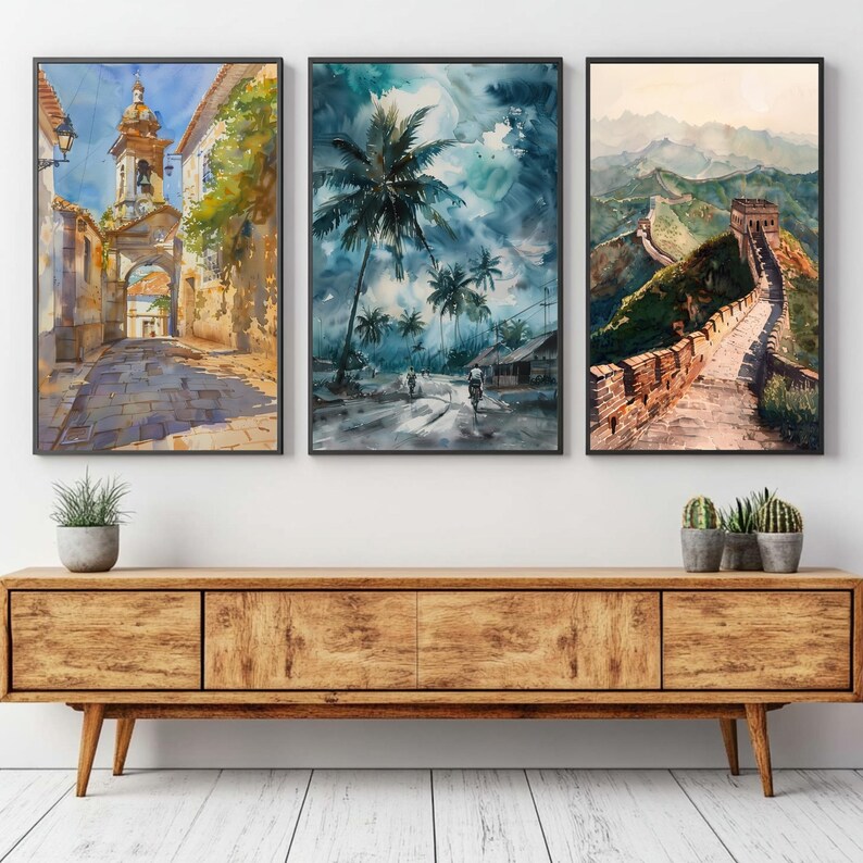Puede incluir: Tres pinturas de acuarela enmarcadas que representan escenas arquitect&oacute;nicas y paisaj&iacute;sticas. Una muestra una calle europea, otra una escena tropical con palmeras y la tercera, una vista de la Gran Muralla China. Las pinturas est&aacute;n sobre un mueble de madera.