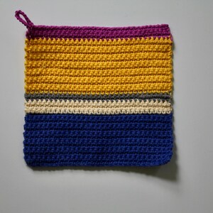 May include: A handmade, square crochet potholder with a hanging loop. The potholder has horizontal stripes in purple, yellow, grey, off-white, and blue. The item is made of yarn.