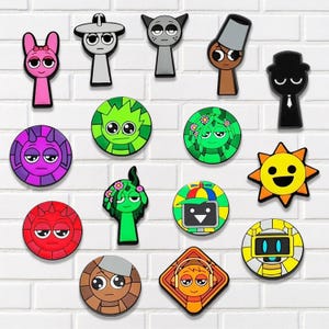 May include: A collection of colorful cartoon character charms in various shapes. The charms include a pink bunny, a gray robot, a green creature with flowers, a yellow sun, and other unique designs. They are attached to a white brick wall.
