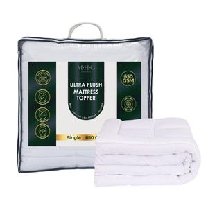 May include: A white Ultra Plush Mattress Topper, 650 GSM, in a clear plastic bag with a handle. The packaging features text and icons in green and gold. A folded mattress topper is displayed next to the packaging.