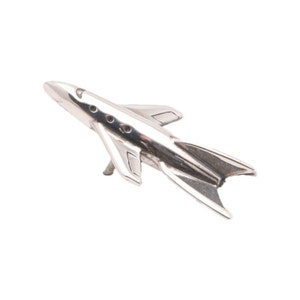 May include: A silver model of a futuristic jet airplane with a pointed nose and swept wings.