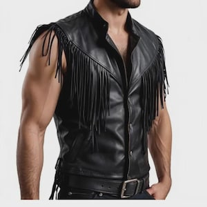Puede incluir: Chaleco de cuero negro con flecos en los hombros. El chaleco tiene una cremallera frontal, un cuello y un cinturón con hebilla plateada. El chaleco sin mangas parece estar hecho de cuero genuino.