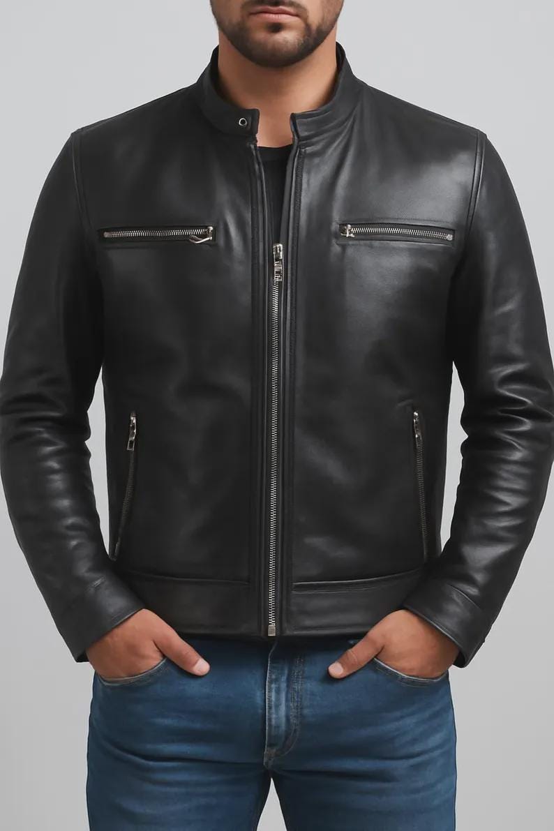 May include: Black leather jacket with a stand-up collar and silver zippers. The jacket has two zippered chest pockets and two side pockets. The model is wearing blue jeans. The jacket is a classic style.