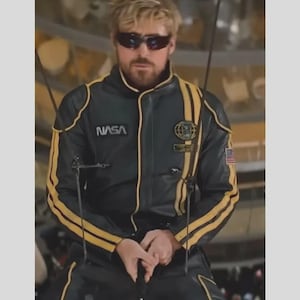 May include: A black leather jacket with yellow stripes along the sleeves and torso. The jacket features a NASA logo on the right chest, a circular emblem on the left chest, and a small American flag patch on the left sleeve. The jacket has a high collar.