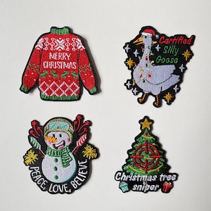 Könnte beinhalten: Vier weihnachtliche, gestickte Aufnäher. Designs umfassen einen roten Pullover mit "Merry Christmas", eine Gans mit Weihnachtsmütze und dem Text "Certified Silly Goose", einen Schneemann mit "Peace, Love, Believe" und einen Weihnachtsbaum mit "Christmas tree sniper".