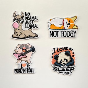 Könnte beinhalten: Vier gestickte Aufnäher mit humorvollen Designs. Einer zeigt ein Lama mit Sonnenbrille und Kaugummi, der Text lautet "NO DRAMA, JUST LLAMA." Ein anderer zeigt einen Corgi mit dem Text "NOT TODAY." Ein Schwein spielt Gitarre mit "I LOVE PORK 'N' ROLL." Ein Panda mit "SLEEP and you?"