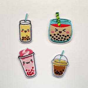May include: Four embroidered bubble tea patches. Each patch depicts a different cup design and colour scheme, including yellow, brown, pink, and a teal-coloured cup. The patches have cute, smiling faces and are outlined in white.