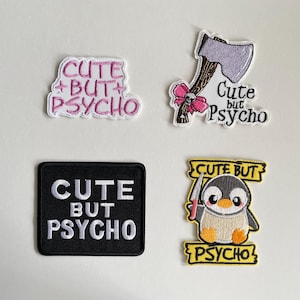 Könnte beinhalten: Vier gestickte Aufnäher mit dem Schriftzug "Cute But Psycho". Designs umfassen den Text in Rosa, eine Cartoon-Axt mit rosa Schleife, einen Pinguin mit Messer und den Text auf einem schwarzen Quadrat.