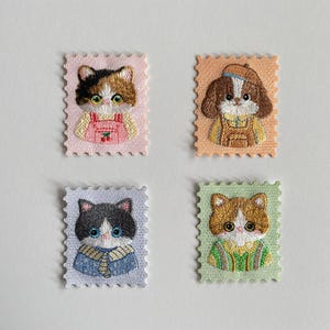 Könnte beinhalten: Eine weiße Keramik-Tasse mit schwarzem Henkel und dem Text "But First, Coffee" in schwarzer, handschriftlicher Schrift. Die Tasse steht auf einer weißen Oberfläche.