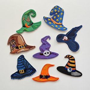 Peut inclure: Collection de patchs brodés en forme de chapeaux de sorcière de différentes couleurs. Les motifs comprennent du vert avec des accents orange, du bleu avec des étoiles dorées, du marron avec une toile d'araignée.