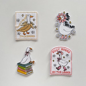 Könnte beinhalten: Vier gestickte Aufnäher mit Cartoon-Gänsen. Einer zeigt eine Gans in einer Bananenschale mit dem Text "I'm a banana". Ein anderer hat eine Gans mit Blumenkranz und dem Text "Goofy Vibes Only". Der dritte zeigt eine Gans auf Büchern. Der letzte sagt "Silly Goose on the Loose".