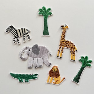 Könnte beinhalten: Gestickte Aufnäher mit Safari-Tieren und Palmen. Enthält ein Zebra, eine Giraffe, einen Elefanten, ein Krokodil, einen Löwen und zwei Palmen. Die Aufnäher haben detaillierte Nähte und leuchtende Farben, ideal zum Dekorieren von Kleidung oder Accessoires.