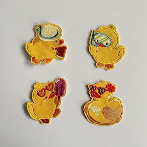 Könnte beinhalten: Vier gestickte gelbe Entenaufnäher mit Sommeraccessoires. Eine Ente trägt einen Hut und hält eine Wassermelone, eine andere hat einen Schnorchel, eine dritte trägt herzförmige Sonnenbrillen und hält ein Eis, und die letzte trägt Sonnenbrillen und eine Blume.