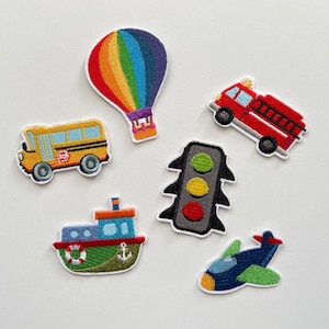 Op de afbeelding: Geborduurde patches met een schoolbus, brandweerwagen, luchtballon, boot, vliegtuig en verkeerslicht. De patches zijn kleurrijk met gedetailleerde steken en een witte rand. Voor kinderkleding en accessoires.