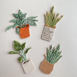 Könnte beinhalten: Vier gestickte Pflanzenaufnäher. Zwei haben grüne Pflanzen in orangefarbenen und beigefarbenen Töpfen. Die anderen beiden haben grüne Pflanzen in weißen und beigefarbenen Töpfen. Die Aufnäher befinden sich auf weißem Hintergrund.