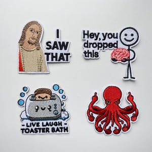 May include: Set of four embroidered patches with humorous designs. Includes a Jesus patch with the text "I SAW THAT", a stick figure holding a brain with the text "Hey, you dropped this", a toaster with the text "LIVE LAUGH TOASTER BATH", and a red octopus.