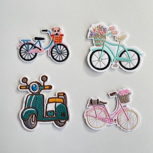 Könnte beinhalten: Vier gestickte Aufnäher mit Transportmotiven. Enthält ein hellblaues Fahrrad mit einem Hund im Korb, einen türkisfarbenen Roller, ein hellblaues Fahrrad mit Blumen und ein rosa Fahrrad mit einer Katze im Korb.