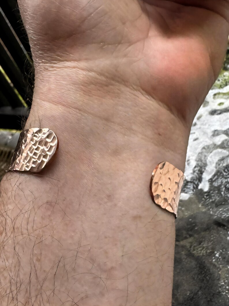 Puede incluir: Una pulsera de pu&ntilde;o de cobre con una textura martillada. El dise&ntilde;o abierto permite un f&aacute;cil uso. La pulsera es de color marr&oacute;n rojizo c&aacute;lido.