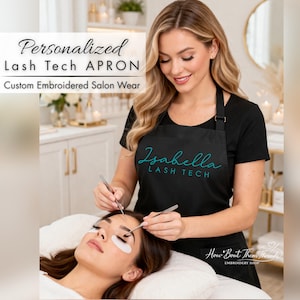 May include: A black apron with the text "Isabella LASH TECH" in teal script. The apron is worn by a person performing a lash service on a client. The image also includes the text "Personalized Lash Tech APRON" and "Custom Embroidered Salon Wear".