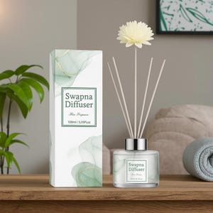 Może przedstawiać: Zestaw dyfuzora zapachowego do domu z biało-zielonym pudełkiem w wzory i szklaną butelką. Butelka zawiera patyczki i ozdobny kwiat. Na pudełku napis "Swapna Diffuser" i "100ml/5.35Fl oz".