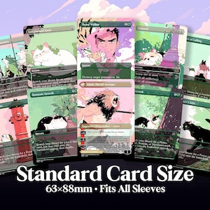 May include: A collection of illustrated trading cards with various designs, including cats, people, and a lion. The cards feature text and are labeled "Standard Card Size" with dimensions of 63x88mm, fitting all sleeves.