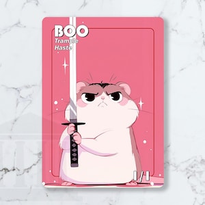 May include: A pink card featuring a cartoon hamster holding a sword. The card has the word "BOO" at the top, with "Trample Haste" below. The hamster has an angry expression. The card is marked 1/1.