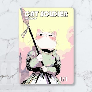 Peut inclure: Une carte à collectionner rectangulaire représentant un chat blanc en armure vert clair et noire tenant une longue lance. Le texte CAT SOLDIER et Vigilance figure en haut, avec 0/0 en bas. Le fond montre un ciel jaune pâle et des nuages roses.