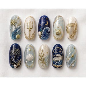 May include: A set of ten oval-shaped press-on nails featuring intricate designs including gold trident, seashell, and column motifs, navy blue night skies with stars and moons, marble textures, and small pearl accents arranged in two horizontal rows.
