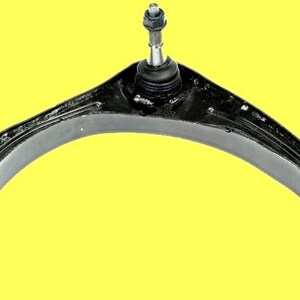 Op de afbeelding: Een zwarte, gebogen draagarm met een kogelgewricht en bussen. Het auto-onderdeel staat tegen een gele achtergrond. De draagarm is van metaal en heeft een bout aan de bovenkant.