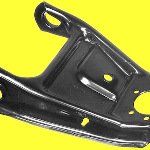 Op de afbeelding: Zwarte metalen auto beugel met een glanzende afwerking. De beugel heeft een unieke vorm met meerdere gaten van verschillende grootte. De achtergrond is effen geel.
