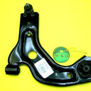 May include: A black suspension control arm with multiple holes and a ball joint at the top. A sticker with a barcode is attached. The background is yellow. The product has the text "WSD" on a green circle.