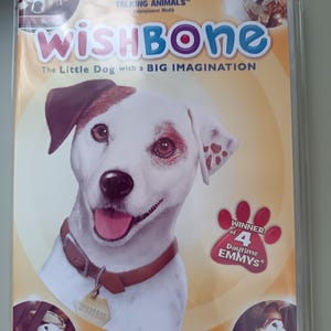 Puede incluir: Caja de DVD para el programa infantil "Wishbone". La portada presenta un perro blanco sonriente con manchas marrones y un collar marrón. El texto incluye "Wishbone", "The Little Dog with a BIG IMAGINATION" y "Winner of 4 Daytime Emmys".