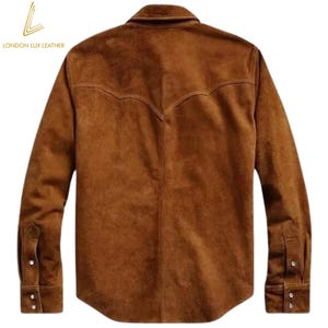 May include: A brown suede shirt with a classic Western yoke design on the back. The long-sleeved shirt has buttoned cuffs and a button-down front. The London Lux Leather logo is visible in the upper left corner.