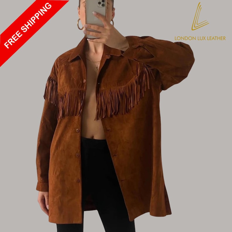 May include: A brown suede jacket with fringe detailing across the chest and sleeves. The jacket has a button-down front and a collared neckline. The words "LONDON LUX LEATHER" are printed on the upper right corner. The words "FREE SHIPPING" are printed on the upper left corner.